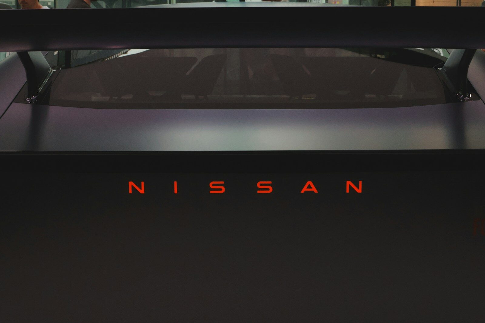 Nissan logo illuminated in red on a dark car
