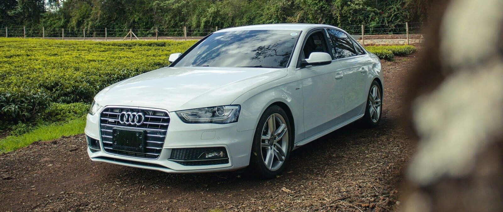 A white car parked on a dirt road