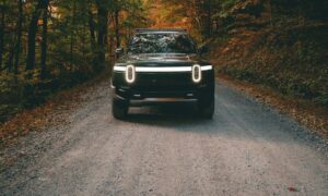 a car on a dirt road surrounded by trees