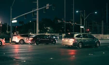 Cars waiting at a traffic light at night.