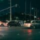 Cars waiting at a traffic light at night.