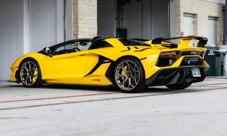 yellow lamborghini aventador parked in front of white building