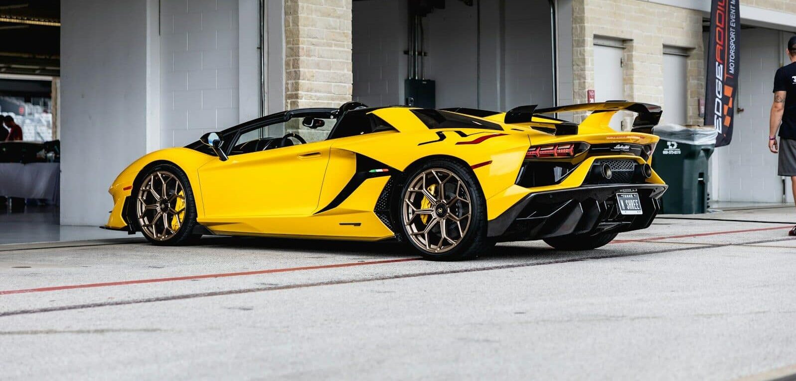 yellow lamborghini aventador parked in front of white building