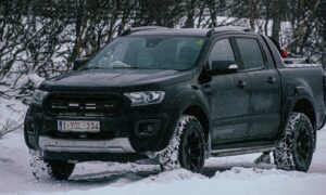 a black truck is parked in the snow