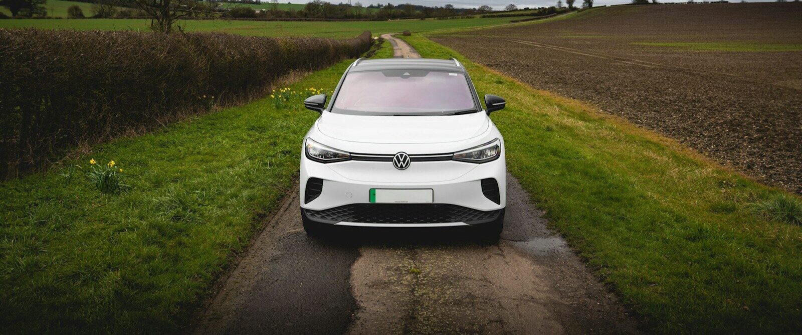 White electric car parked on a rural road