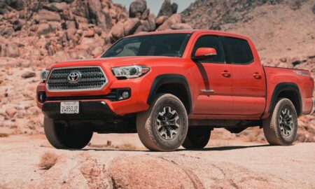 red chevrolet crew cab pickup truck on brown sand