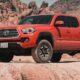 red chevrolet crew cab pickup truck on brown sand