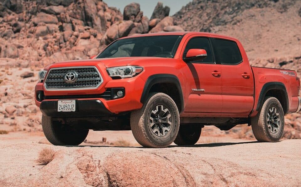 red chevrolet crew cab pickup truck on brown sand