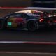 Race car with red bull livery speeds on track.