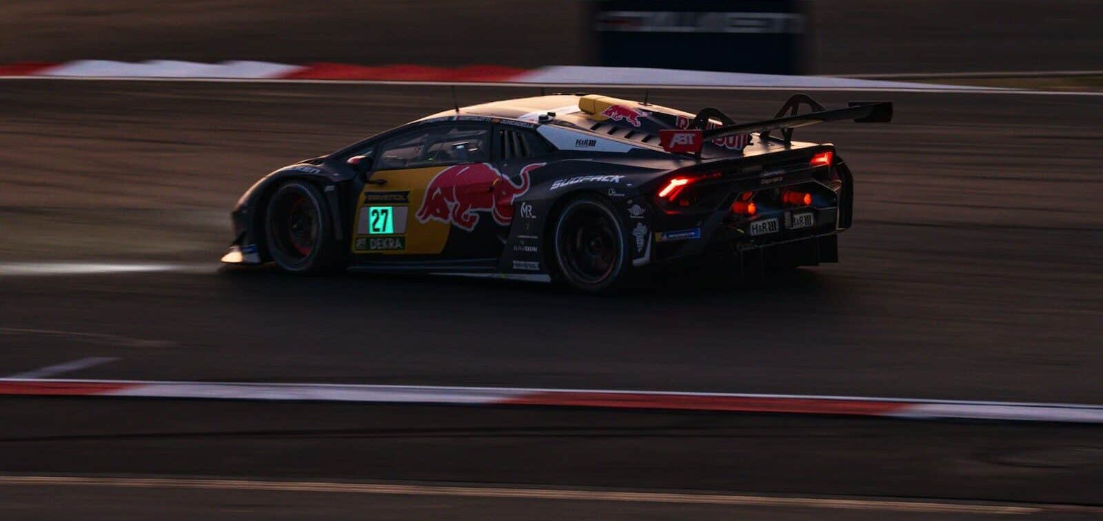 Race car with red bull livery speeds on track.
