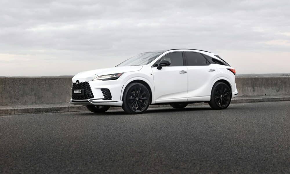 A white lexus suv is parked on the road.