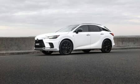 A white lexus suv is parked on the road.