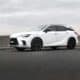 A white lexus suv is parked on the road.