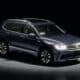 Dark blue suv parked in a studio with spotlights.