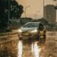 a car driving down a rain soaked street