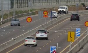 a large passenger jet flying over a busy highway