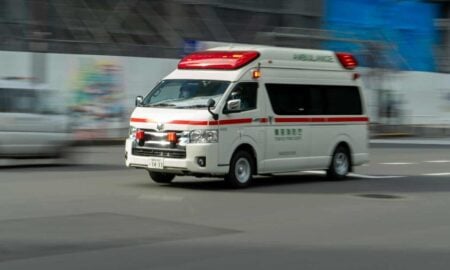 an ambulance driving down a street next to a building
