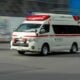 an ambulance driving down a street next to a building