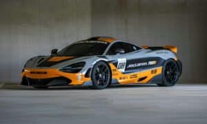 A grey and orange mclaren race car parked indoors