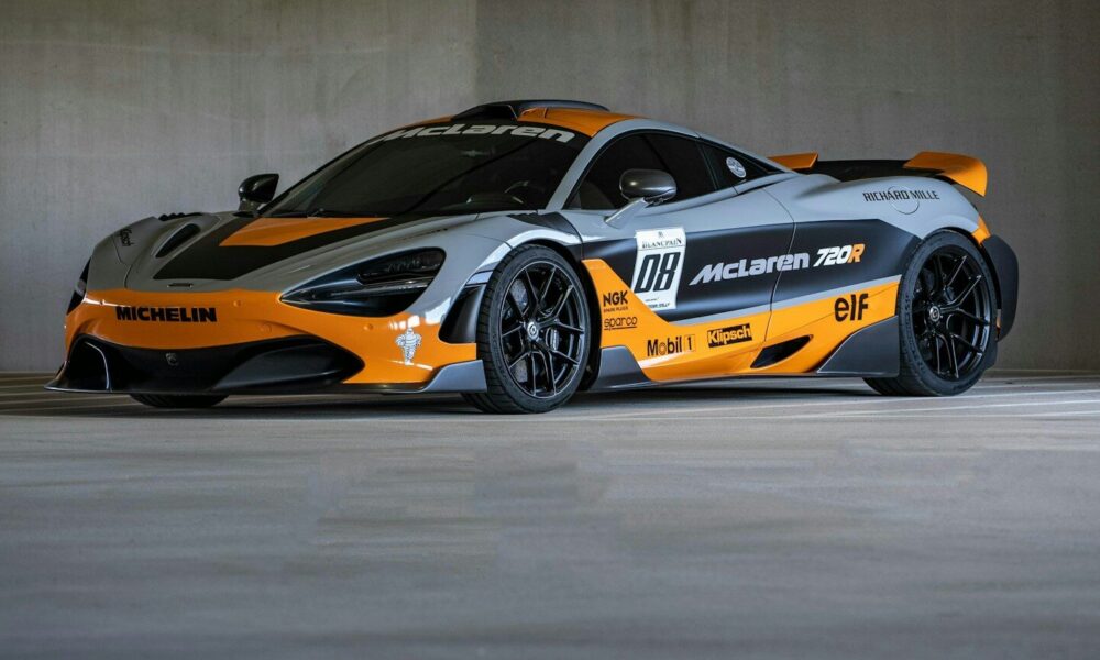 A grey and orange mclaren race car parked indoors