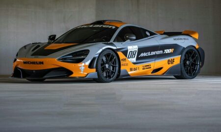 A grey and orange mclaren race car parked indoors