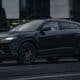A black lamborghini urus suv parked on the street.