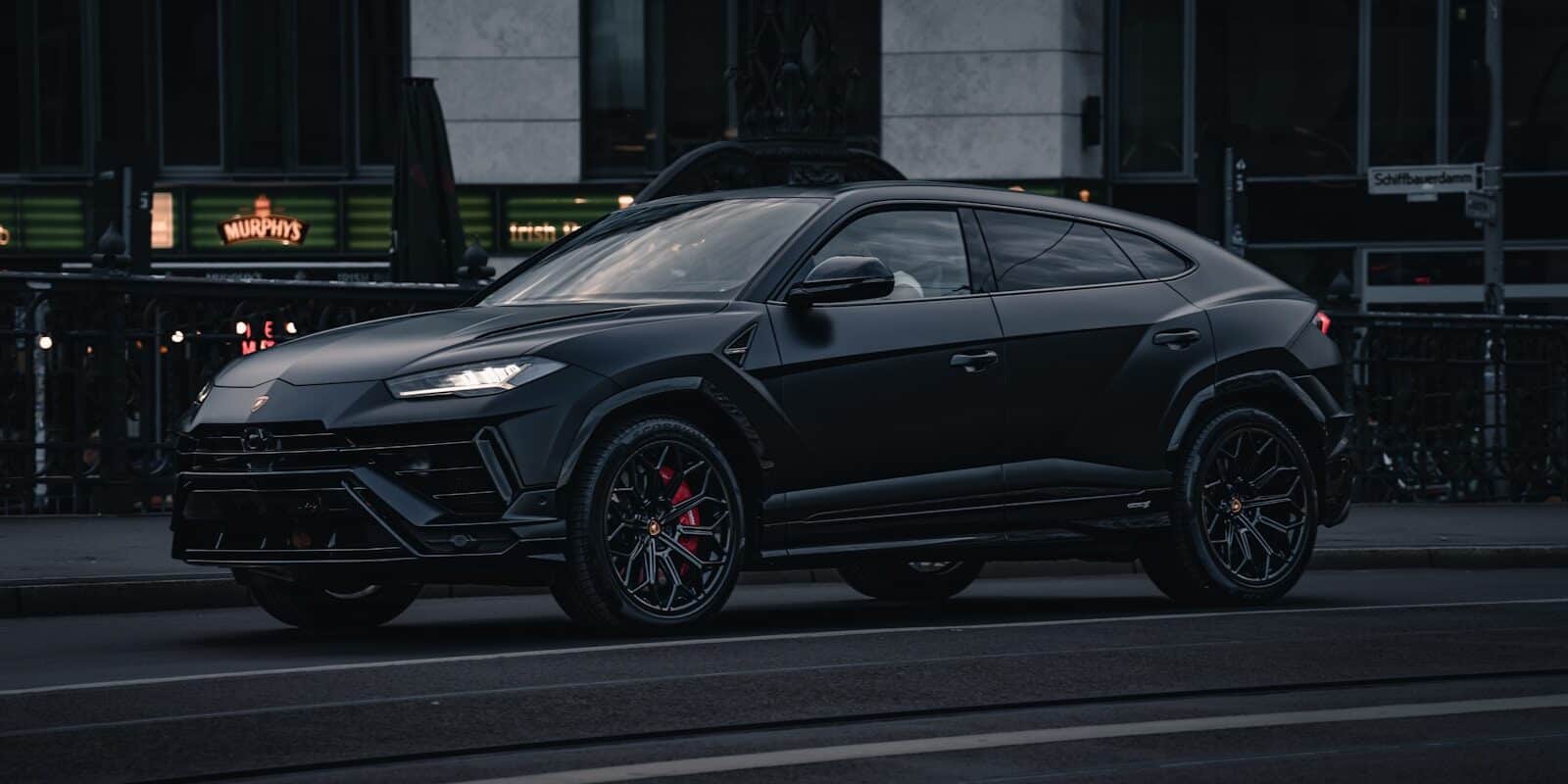 A black lamborghini urus suv parked on the street.