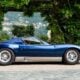 A blue sports car parked in front of a house