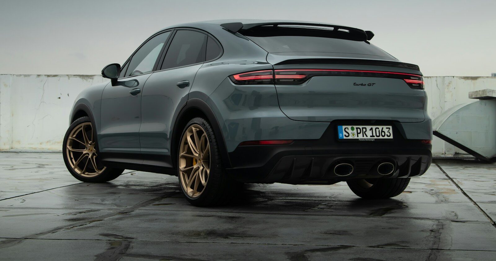 a grey porsche cayen is parked in a parking lot