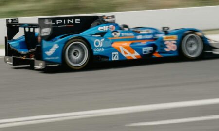 A blue race car driving down a race track
