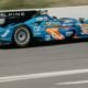 A blue race car driving down a race track