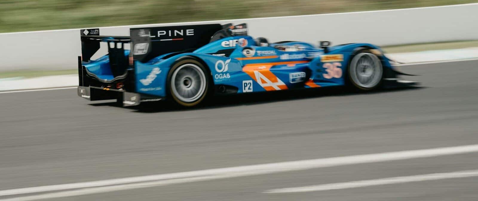 A blue race car driving down a race track