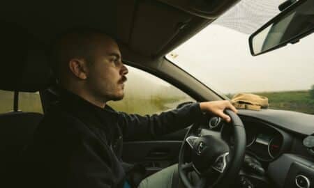 a man driving a car on a rural road