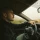 a man driving a car on a rural road