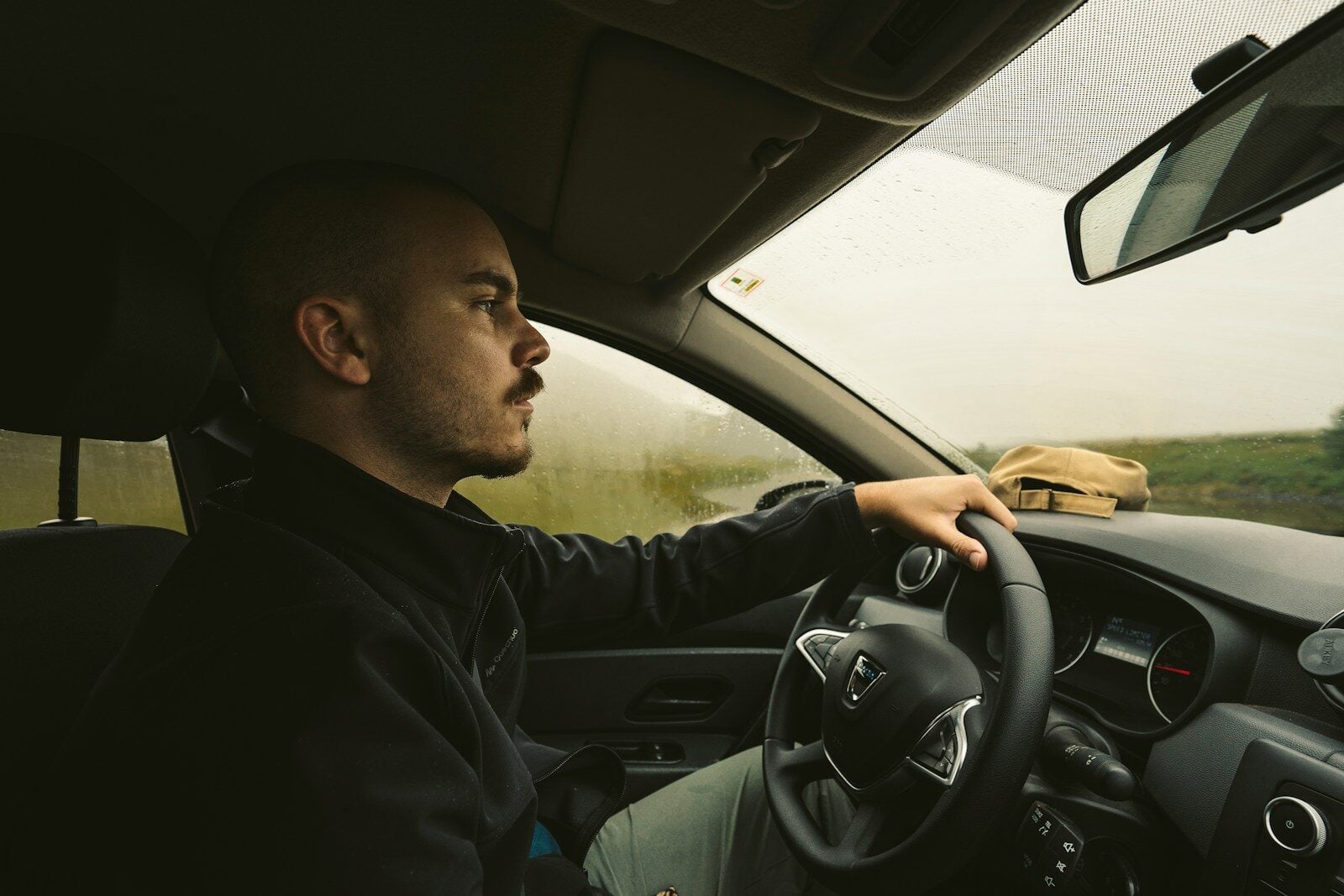 a man driving a car on a rural road
