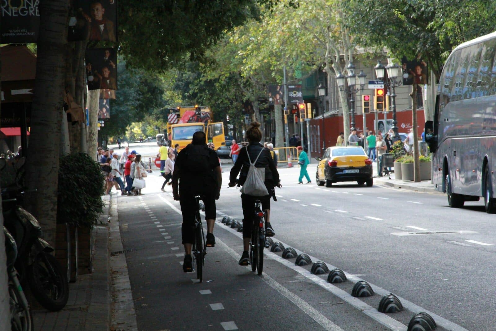 Two cyclists ride on a city street