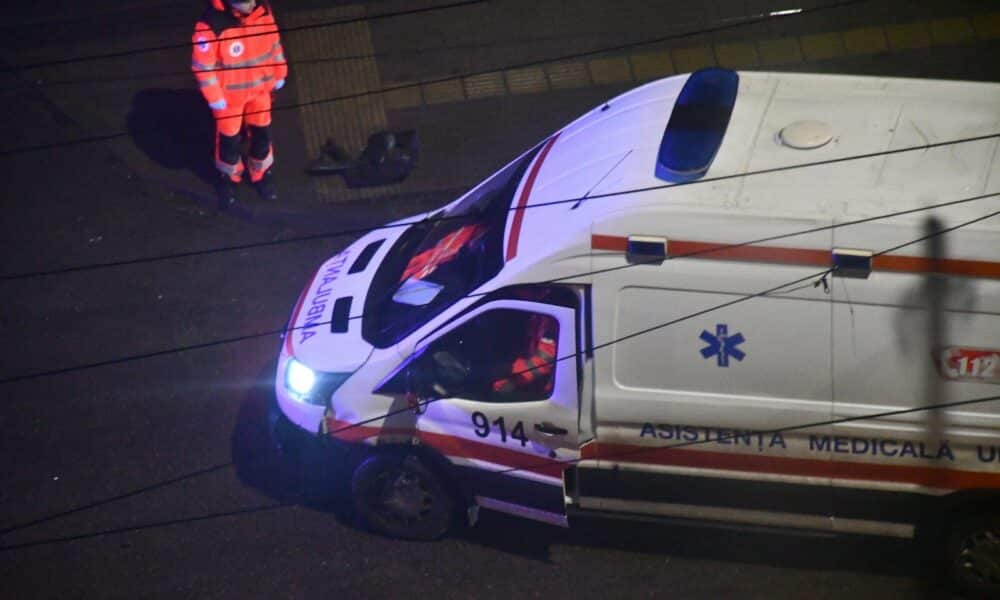 Paramedic stands near an ambulance at night