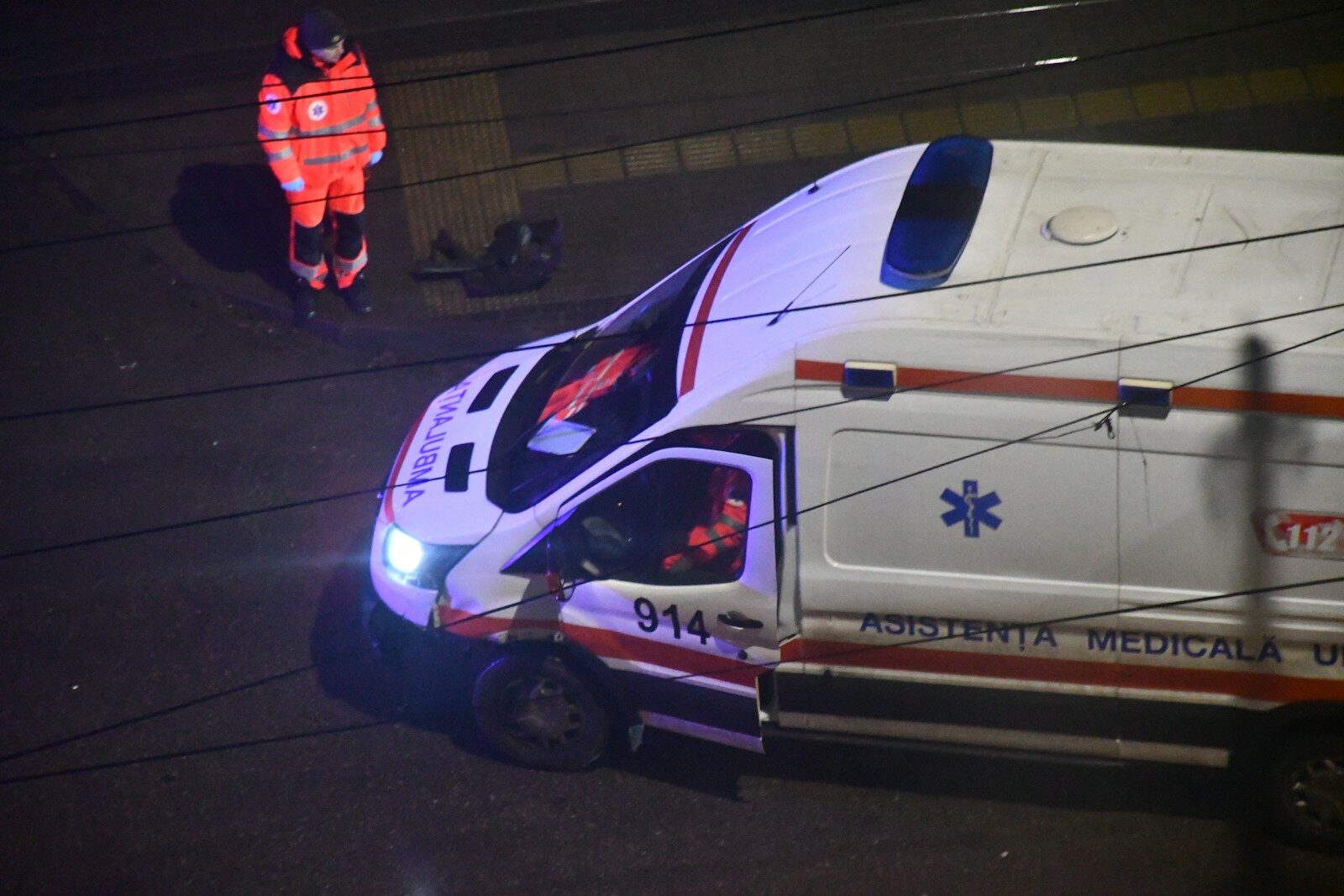 Paramedic stands near an ambulance at night