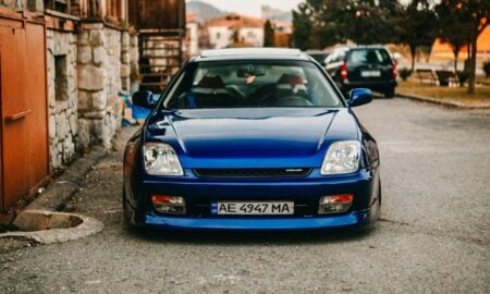 Blue sports car parked on a street with old buildings
