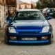 Blue sports car parked on a street with old buildings