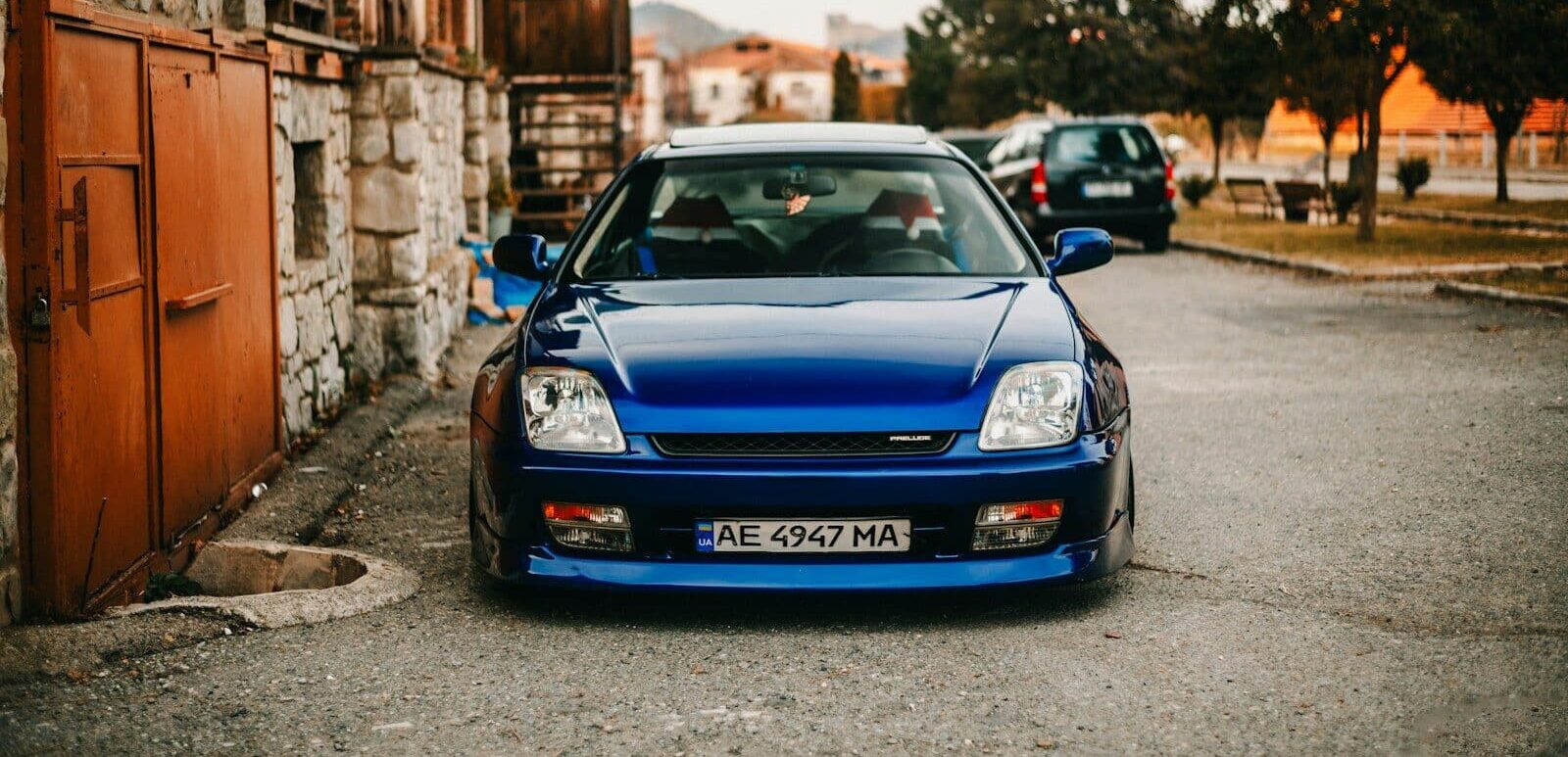 Blue sports car parked on a street with old buildings